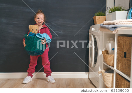 girl is doing laundry at home. girl is doing laundry at home. 63139000