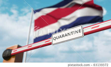 Barrier gate with QUARANTINE sign being closed with flag of Costa Rica as a background. Costa Rican border closure or infection related isolation 63139372