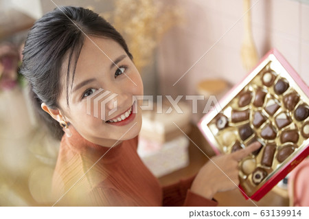 Young woman choosing chocolate Young woman choosing chocolate 63139914
