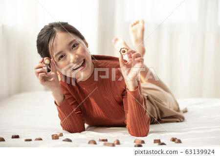 A prone woman choosing chocolate 63139924