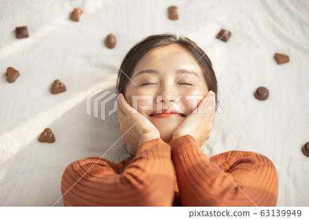 Young woman lying down with chocolate 63139949