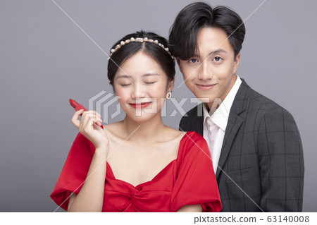 Gray background portrait of young couple dressed up 63140008