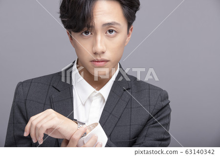 Portrait of male wearing formal wear on gray background Portrait of male wearing formal wear on gray background 63140342