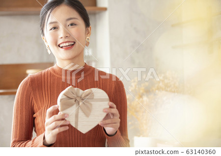 Young woman with gift box Young woman with gift box 63140360