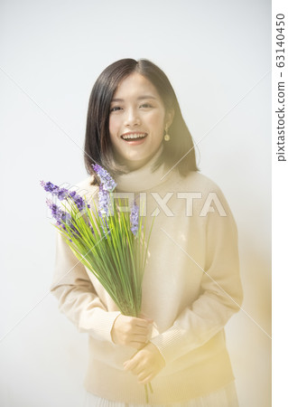 Portrait of young woman holding flowers 63140450