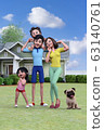 站立在房子前面的一個微笑的家庭在藍天下 63140761