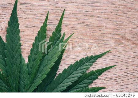 Marijuana leaf on wooden background top view - 63145279