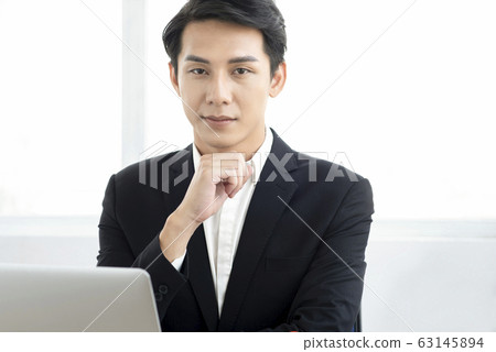 Young businessman in a suit working in the office Young businessman in a suit working in the office 63145894