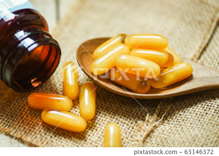 Royal jelly capsules in wooden spoon and sack 63146372