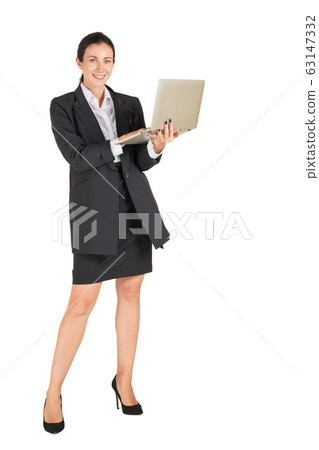 A business woman in a black suit with a smile typing on a computer notebook. A business woman in a black suit with a smile typing on a computer notebook. 63147332