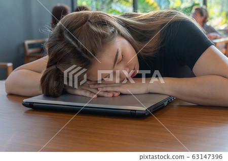 Asian woman sleep with computer laptop on table 63147396