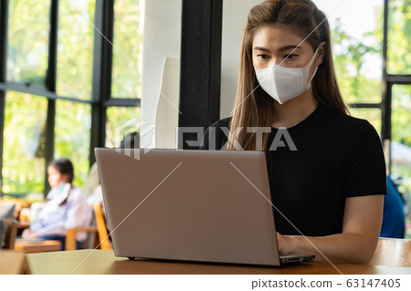 Business Asian young woman working with computer laptop wearing protection mask coughing have fever Business Asian young woman working with computer laptop wearing protection mask coughing have fever 63147405