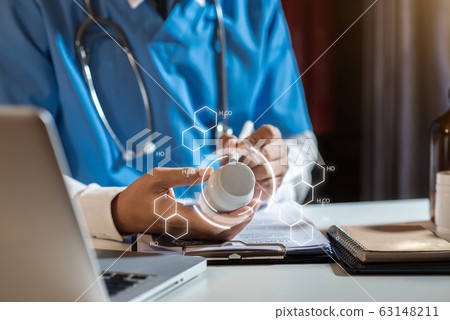 Doctor's hands writing prescription and holding bottle with pills. Healthcare, medical and pharmacy concept. 63148211