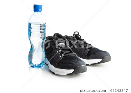 Black sports shoes and bottle of water 63148247