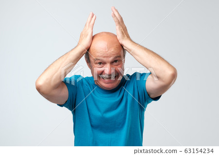 Terrifed troubled senior keeps hands on head, being shocked hearing bad news Terrifed troubled senior keeps hands on head, being shocked hearing bad news 63154234