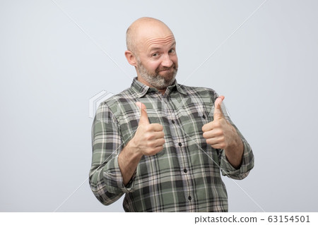 Happy caucasian man with thumbs up gesture, approving your choice. Happy caucasian man with thumbs up gesture, approving your choice. 63154501