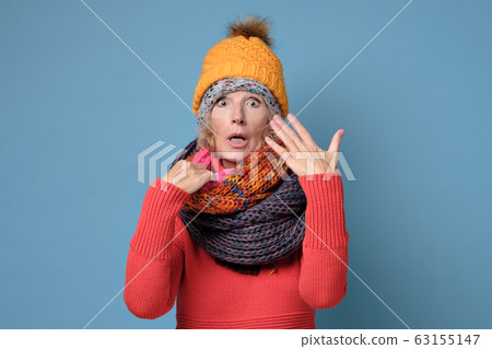 Senior woman in hats and scarfs is covered with sweat Senior woman in hats and scarfs is covered with sweat 63155147