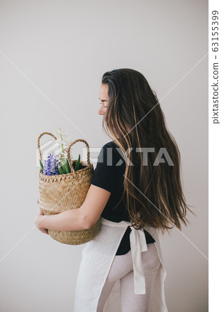 Woman hold basket of flowers on white background. Woman hold basket of flowers on white background. 63155399
