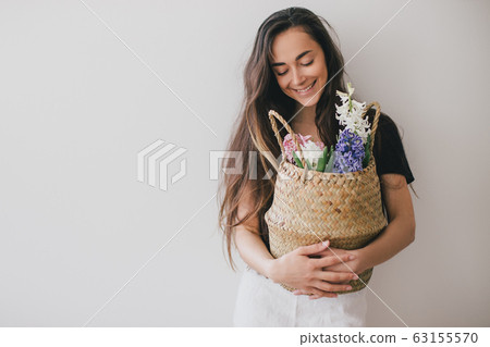 Woman hold basket of flowers on white background. 63155570