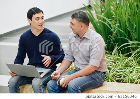 Developer showing presentation to colleague 63156346