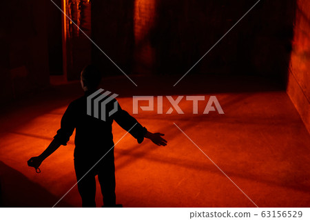 Young adult caucasian catholic priest on dark red 63156529