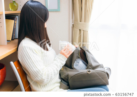 Woman preparing disposable baby bottle Woman preparing disposable baby bottle 63156747