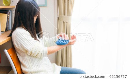 A woman cooling her wrists with an ice bag 16: 9 A woman cooling her wrists with an ice bag 16: 9 63156757