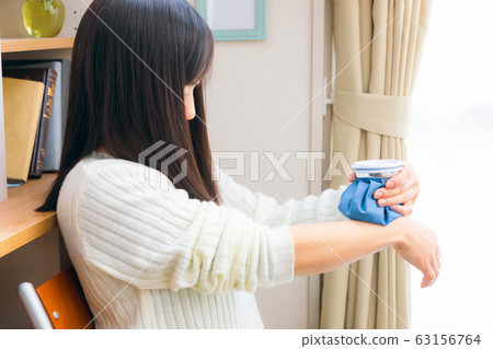 Woman chilling her wrist with ice cubes 63156764