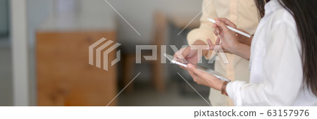 Side view of two university students consulting on 63157976