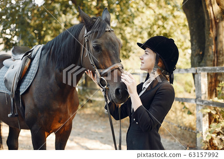 The rider in black form trains with the horse The rider in black form trains with the horse 63157992