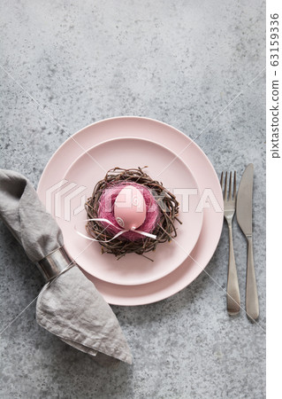 Easter table setting with pink plate decorated egg 63159336