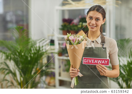 Woman Holding Follow Sign in Flower Shop Woman Holding Follow Sign in Flower Shop 63159342