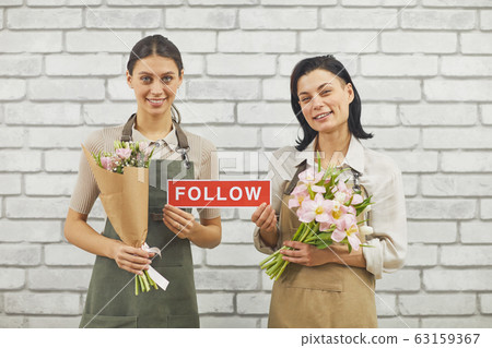 Flower Shop Saleswomen Holding FOLLOW Sign Flower Shop Saleswomen Holding FOLLOW Sign 63159367