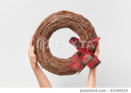 Handcraft round wreath from twigs in the woman's hands. 63160020