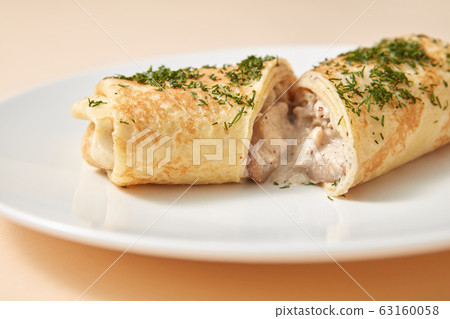 Close-up rolled pancake with filling from chicken and mushroom. 63160058
