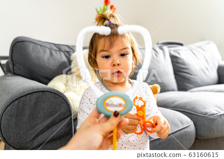Baby toddler girl playing with doctor's kit and doll toys Baby toddler girl playing with doctor's kit and doll toys 63160615