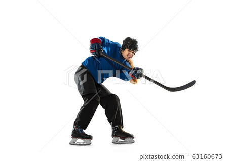 Young female hockey player with the stick on ice court and white background 63160673