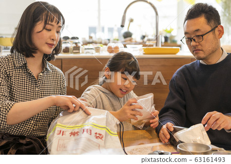 一對夫婦看著一個孩子把行李放在應急外賣袋裡 一對夫婦看著一個孩子把行李放在應急外賣袋裡 63161493