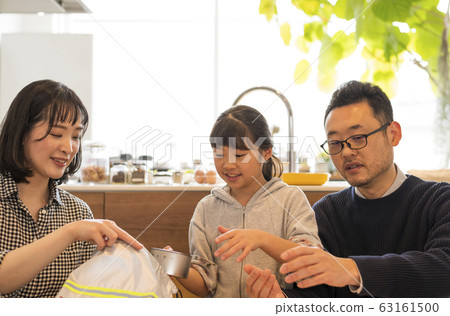 一對夫婦看著一個孩子把行李放在應急外賣袋裡 63161500