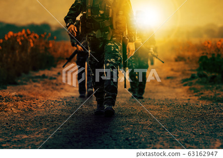 soldier with long rifle gun walking on dirt battle 63162947