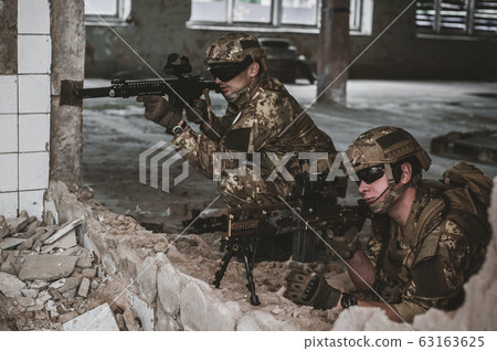 Two men in military camouflage vegetato uniforms 63163625