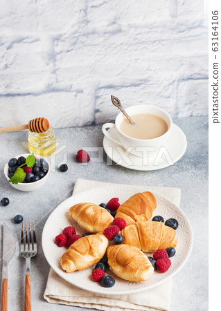 Croissants with fresh raspberries and blueberries Croissants with fresh raspberries and blueberries 63164106