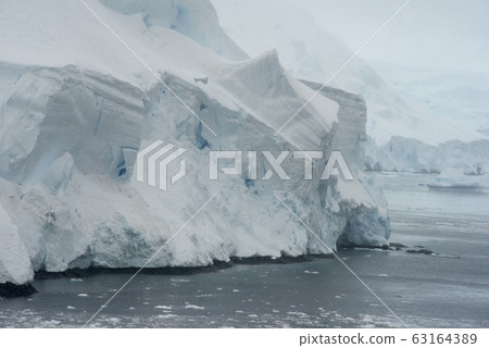 Heavy Snowfall And Glaciers Covering The Coastline Along Lemaire Channel,  Antarctica 63164389