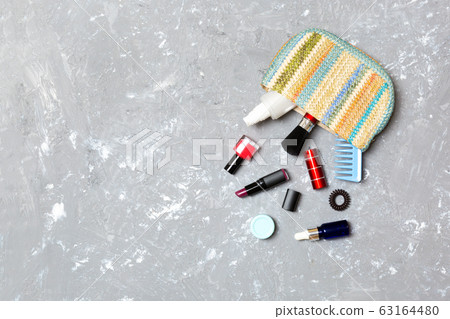 Make up products spilling out of cosmetics bag on Make up products spilling out of cosmetics bag on 63164480