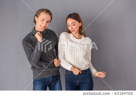 Young couple studio isolated on grey wall concept Young couple studio isolated on grey wall concept 63164708