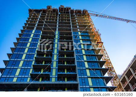 Monolite concrete building under constraction on blue sky background. 63165160
