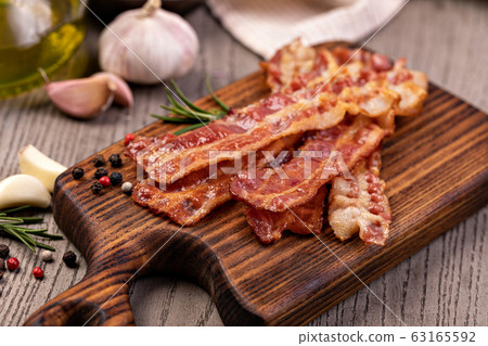 Closeup of slices of crispy hot fried bacon 63165592