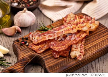 Closeup of slices of crispy hot fried bacon Closeup of slices of crispy hot fried bacon 63165596