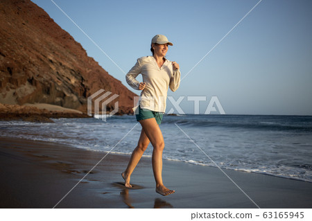 Young woman running on the La Tejita beach Young woman running on the La Tejita beach 63165945