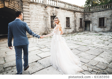 Wedding couple holding hands, groom and bride together on wedding day 63165950